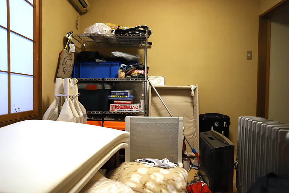 キッチン、リビングなど名古屋で整理収納アドバイザーを取得したお掃除のプロが整理する前の家電や寝具があふれた部屋の写真